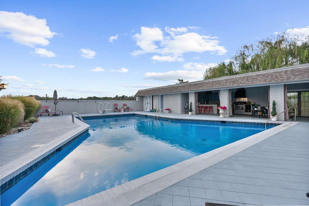 Large Inground Pool with view of outdoor covered kitchen and Living area
