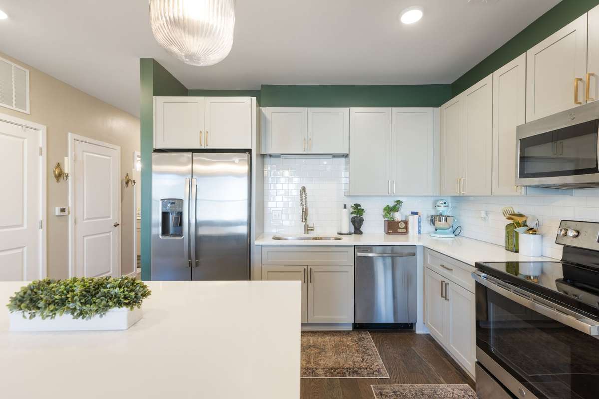 Stainless kitchen appliances and electric range with ample above cabinet storage