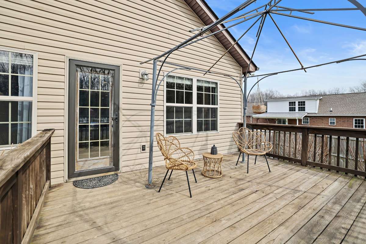 Back deck overlooks the pool and wooded area behind the home.