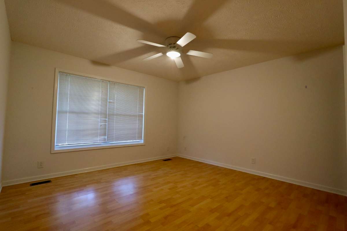 13 x 13 Owner Suite Off of Great Room with Full Bathroom, Walk-In Closet, and Ceiling Fan