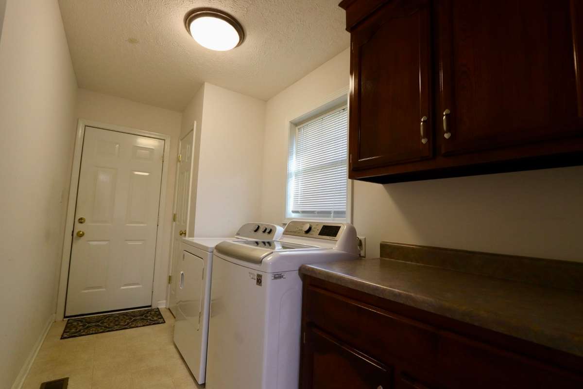 Convenient Laundry Room/Mud Room off of Kitchen with Storage Closet, Washer and Dryer to Convey, and Cabinets with Countertop - Perfect Place to Fold Your Clothes!