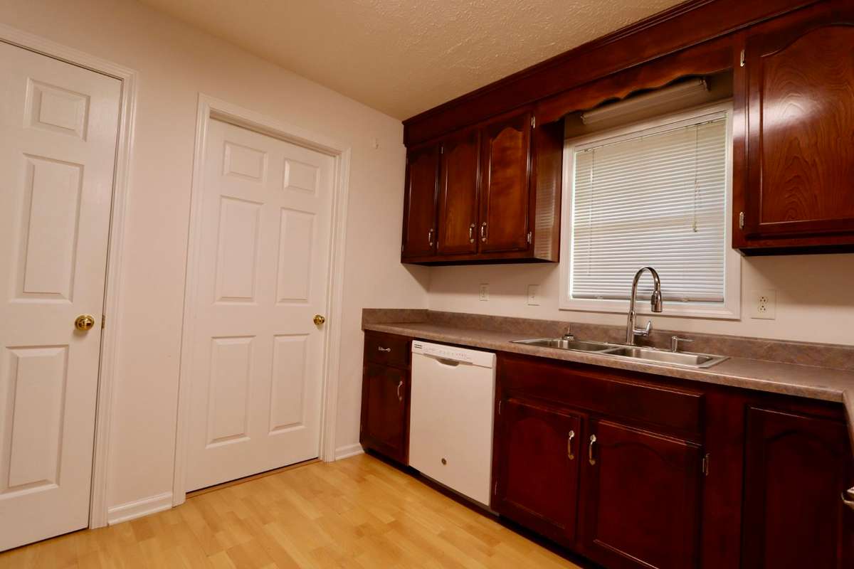 Charming 12x 12 Kitchen with Whirlpool Gas Stove, GE Dishwasher, GE Refrigerator, Coveted Cabinet Space, Lovely Laminate Flooring, and Pantry