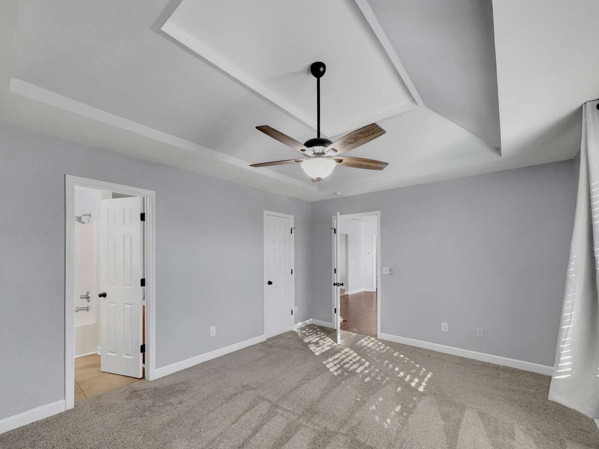 Spacious primary bedroom with stunning tray ceiling