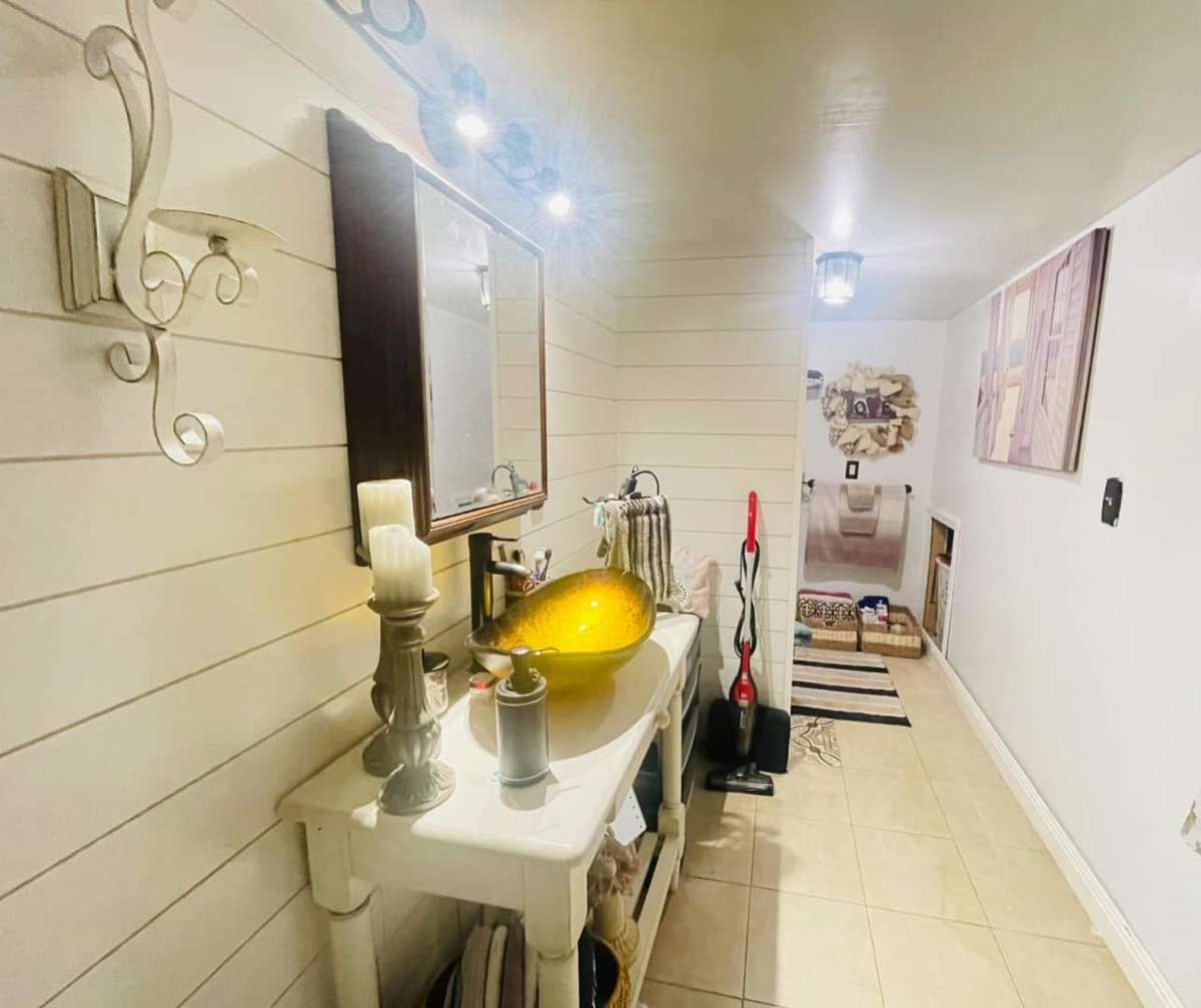 Very stylish full bath with single vanity.
