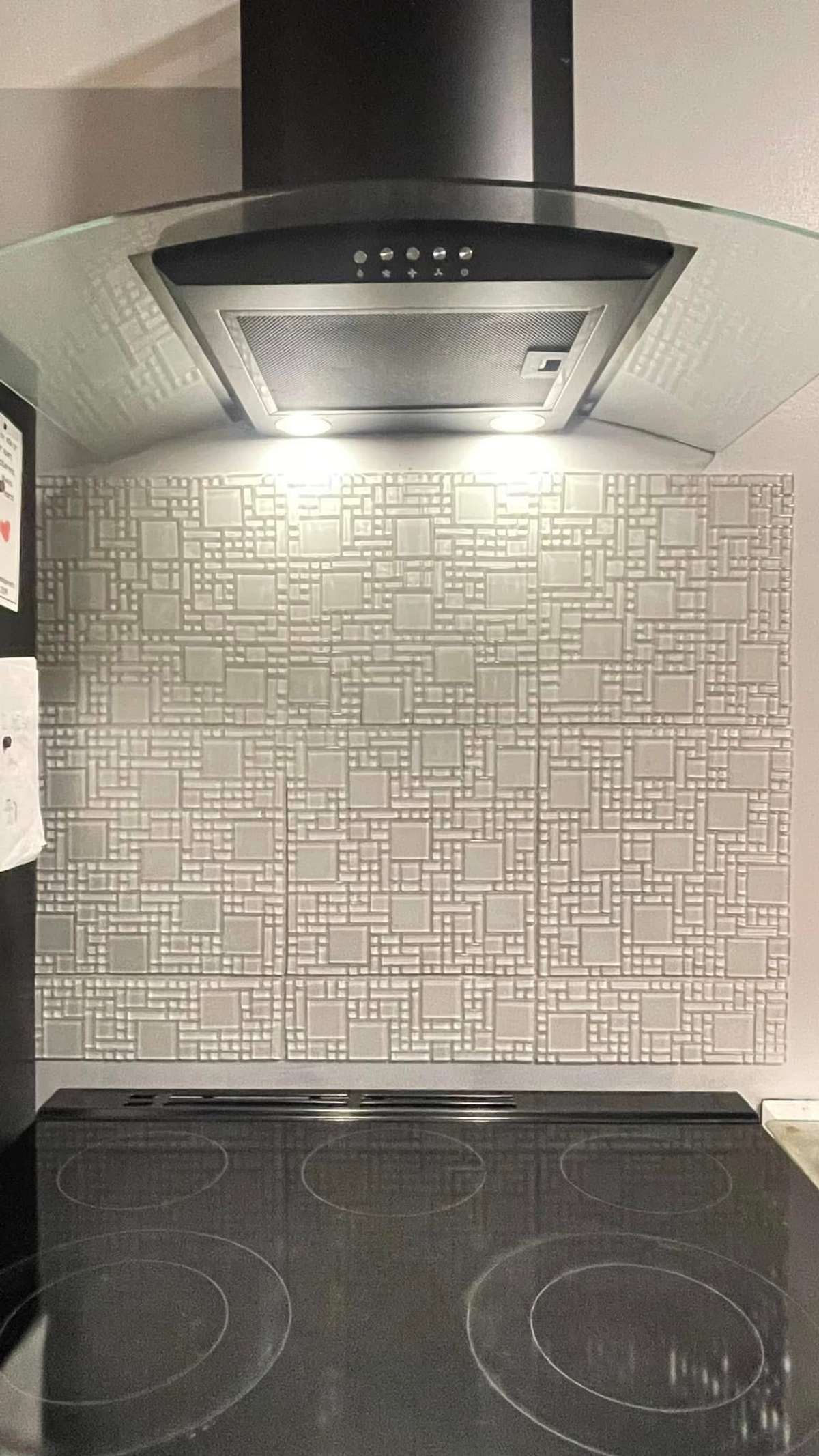 Beautiful tile backsplash at stove/oven, with stylish yet functional vent-a-hood.