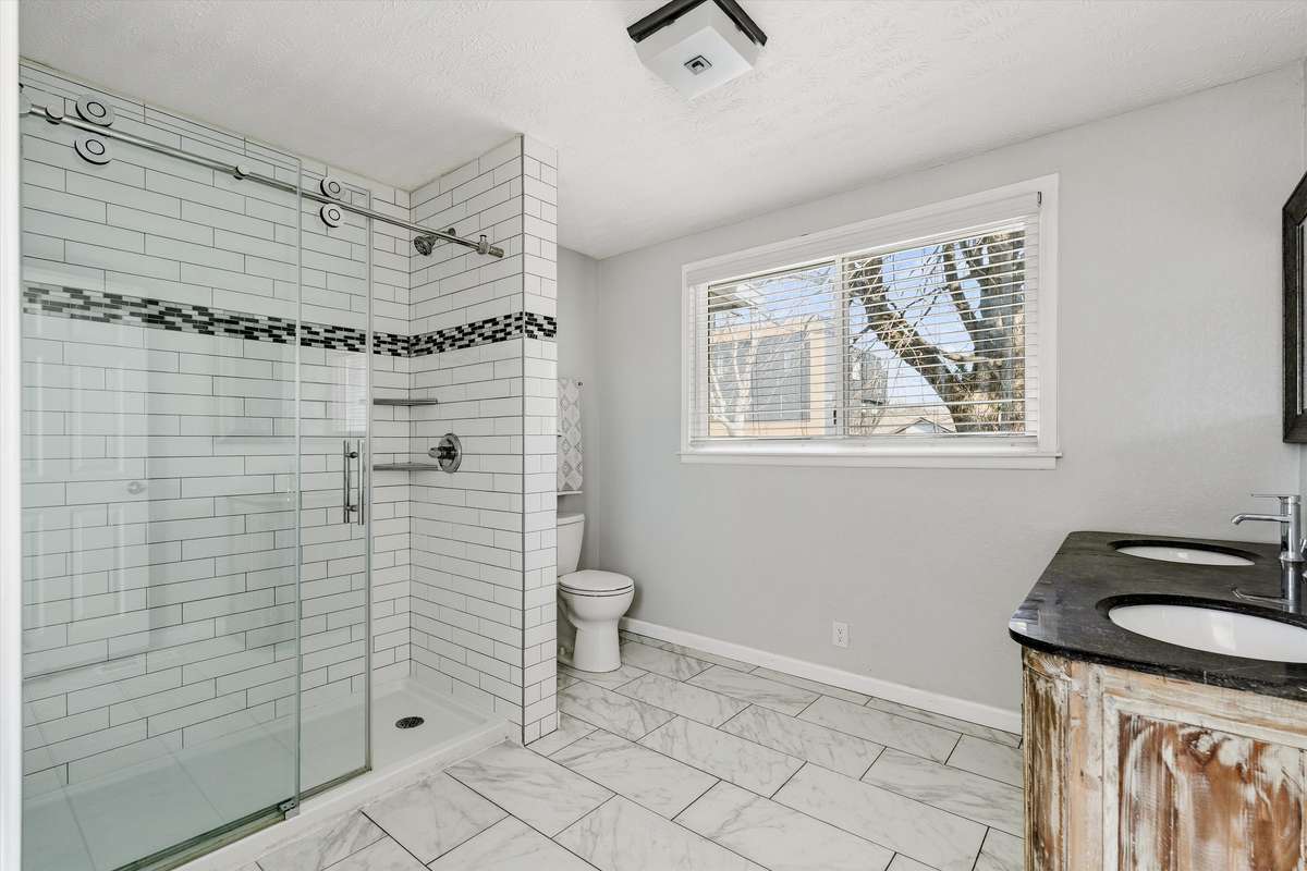 The primary bathroom is also recently renovated with a large walk-in shower and double vanity.