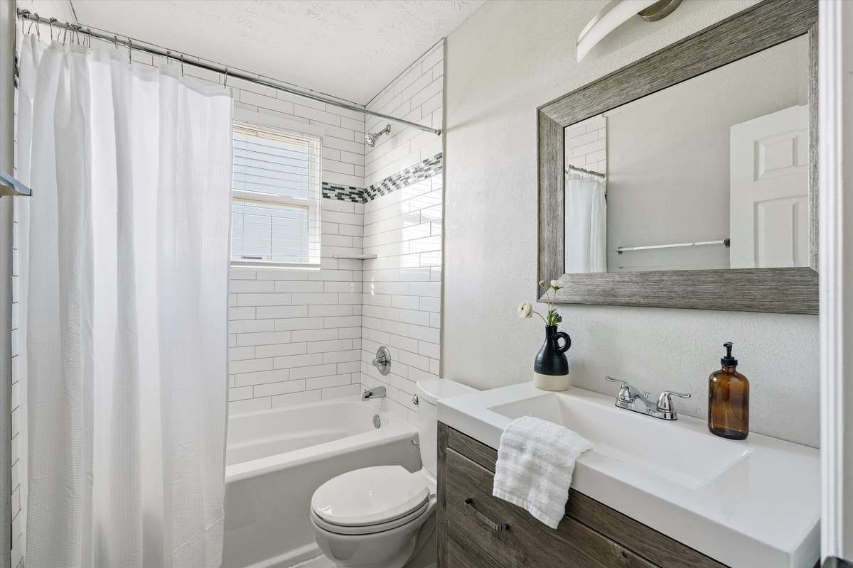 The hall bathroom is recently renovated and has a large vanity with plenty of storage.