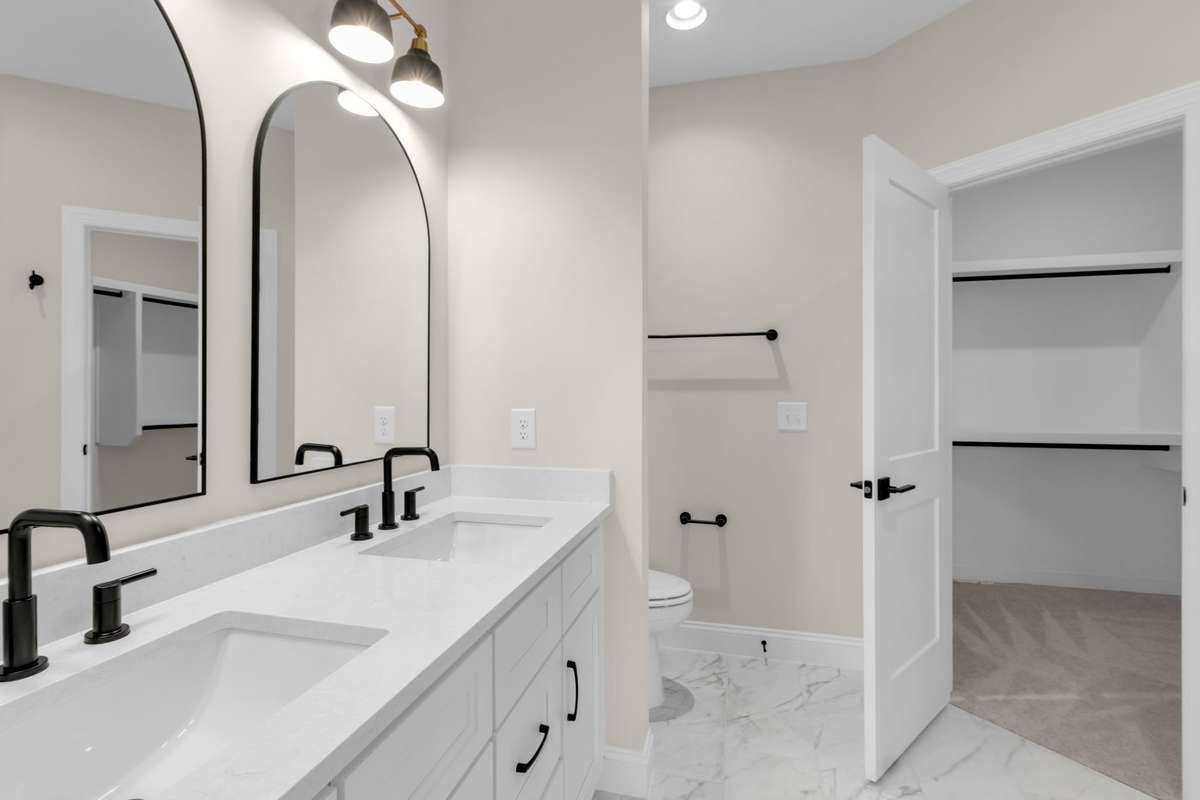 View into the walk-in closet through the owners on suite bathroom that makes getting ready easy and convenient.