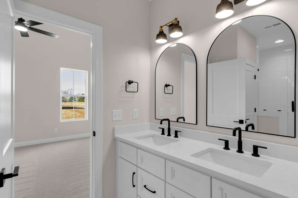 Double vanity with quartz countertops and designer light fixtures with separate mirrors that elevate this area to another level of perfection.