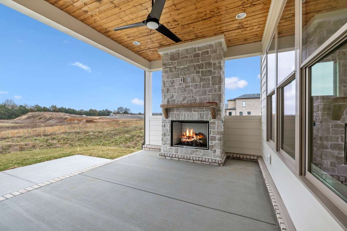 Covered back porch features gas fireplace and real wood ceiling