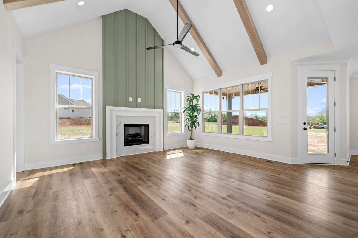 Stunning greatroom features cathedral ceiling with wooden beams.