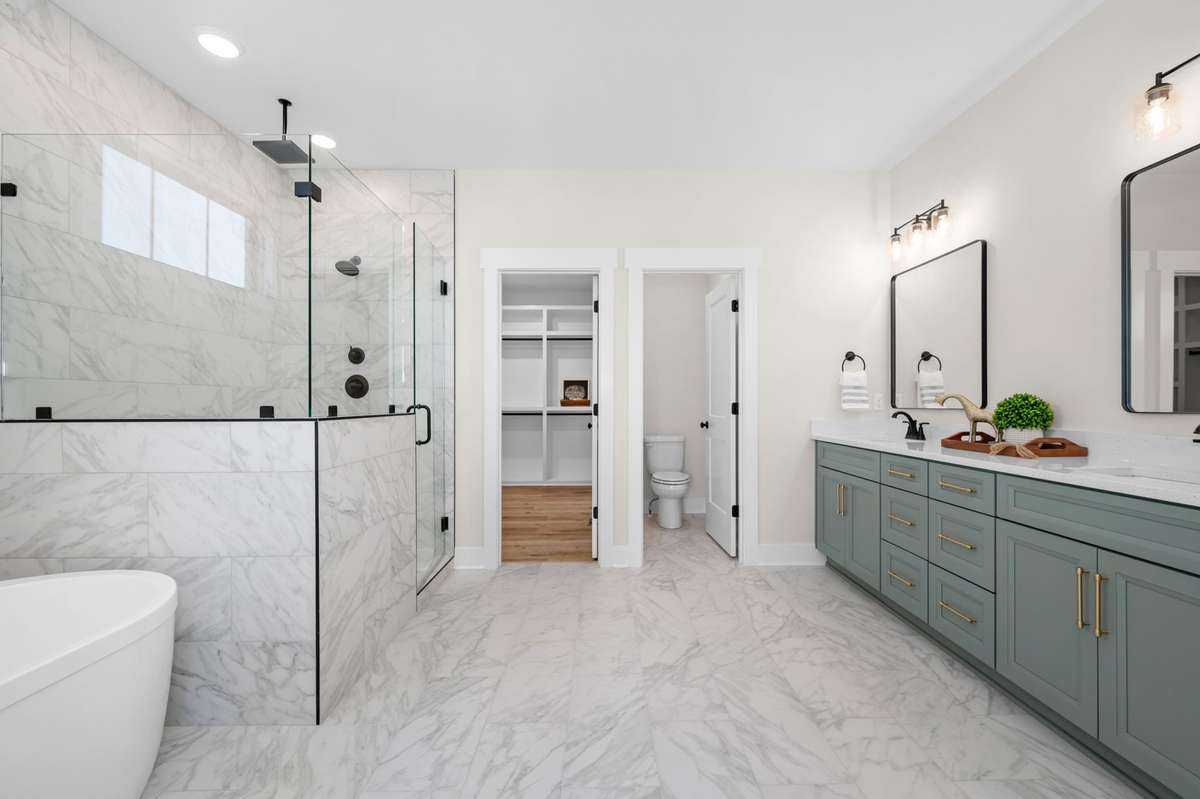 Spacious Primary bath with double vanities, tile shower, and soaking tub.