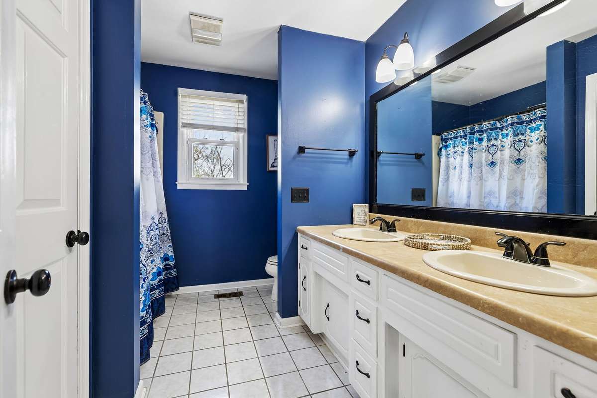 Guest Bathroom on Main Level with Dual Vanity, Linen Closet, Tile Flooring & Shower/Tub Combo