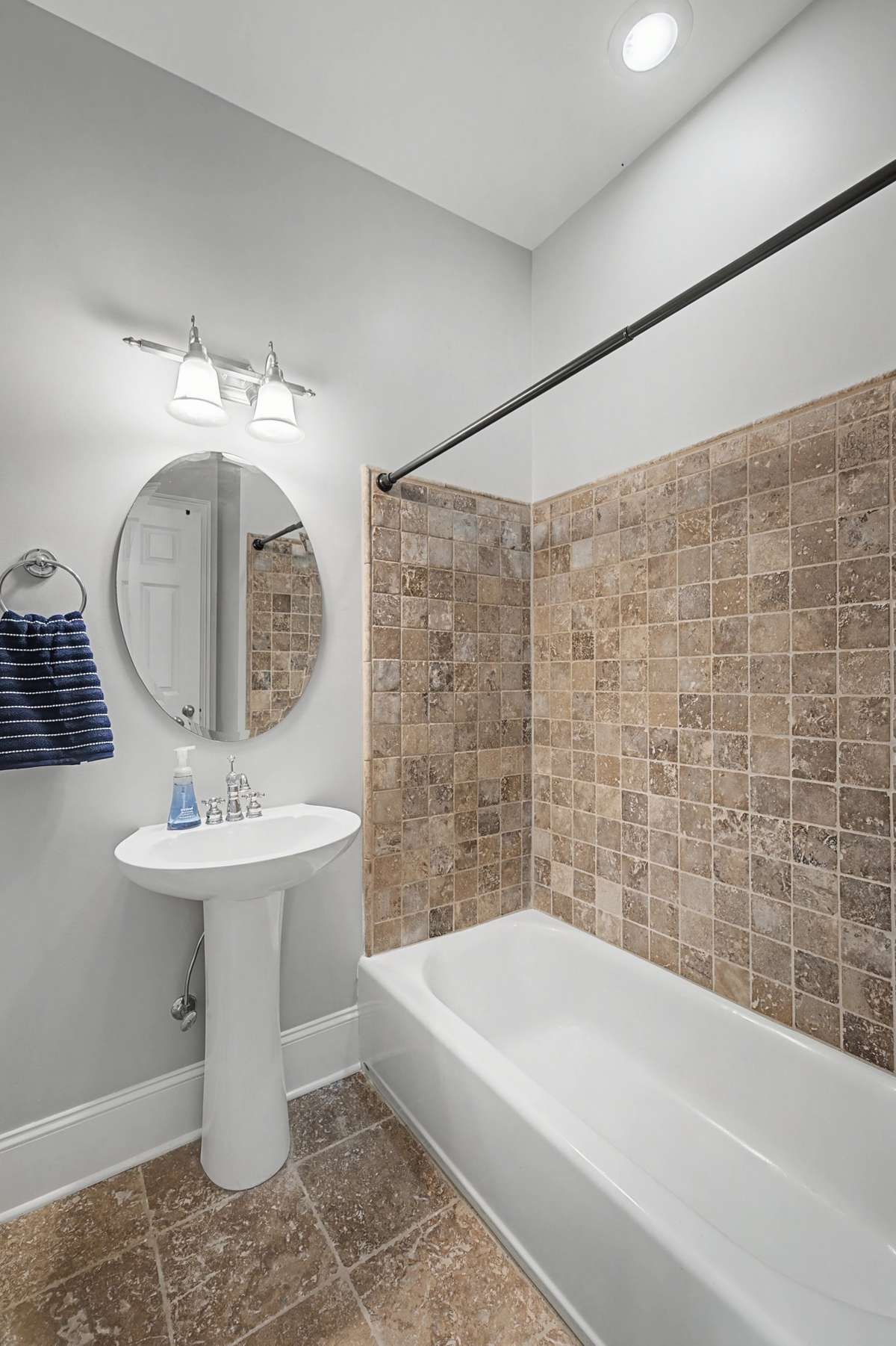 Guest Bathroom: Full secondary bathroom with a pedestal sink and shower/tub combo