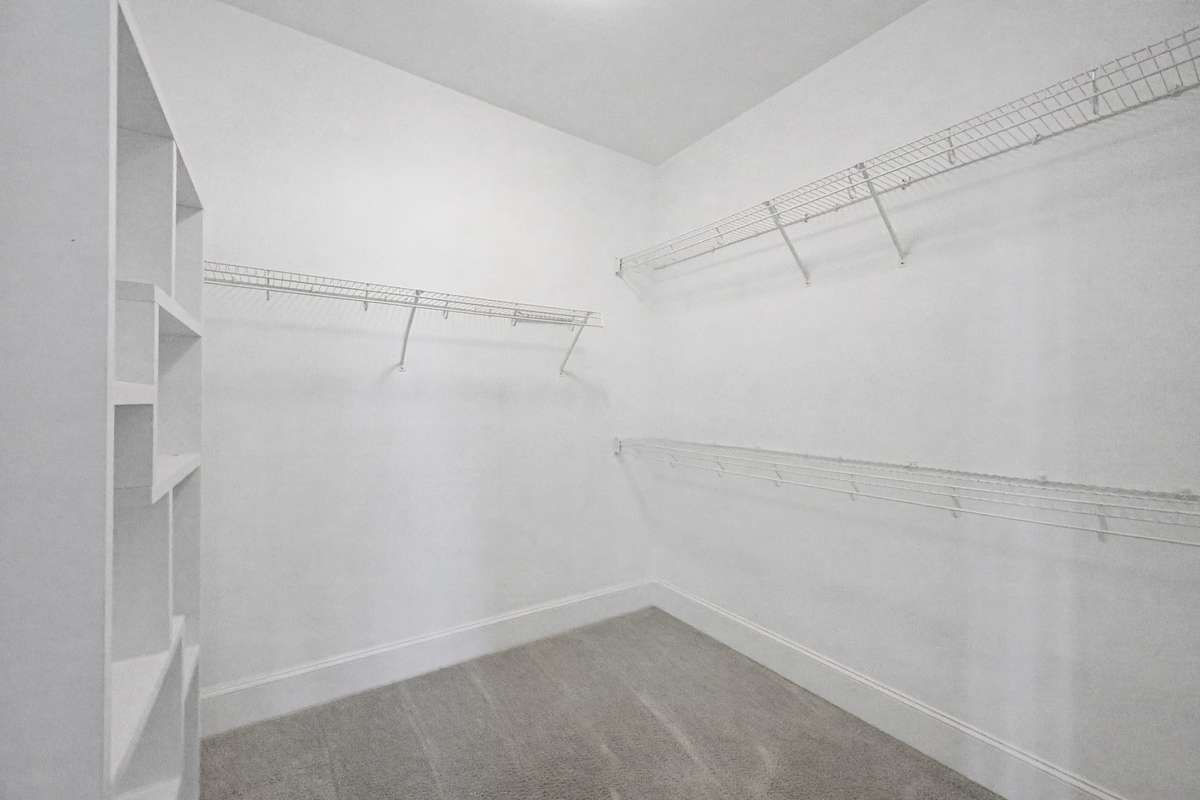 Walk-in Closet: Expansive walk-in closet with built-in shelving and ample storage