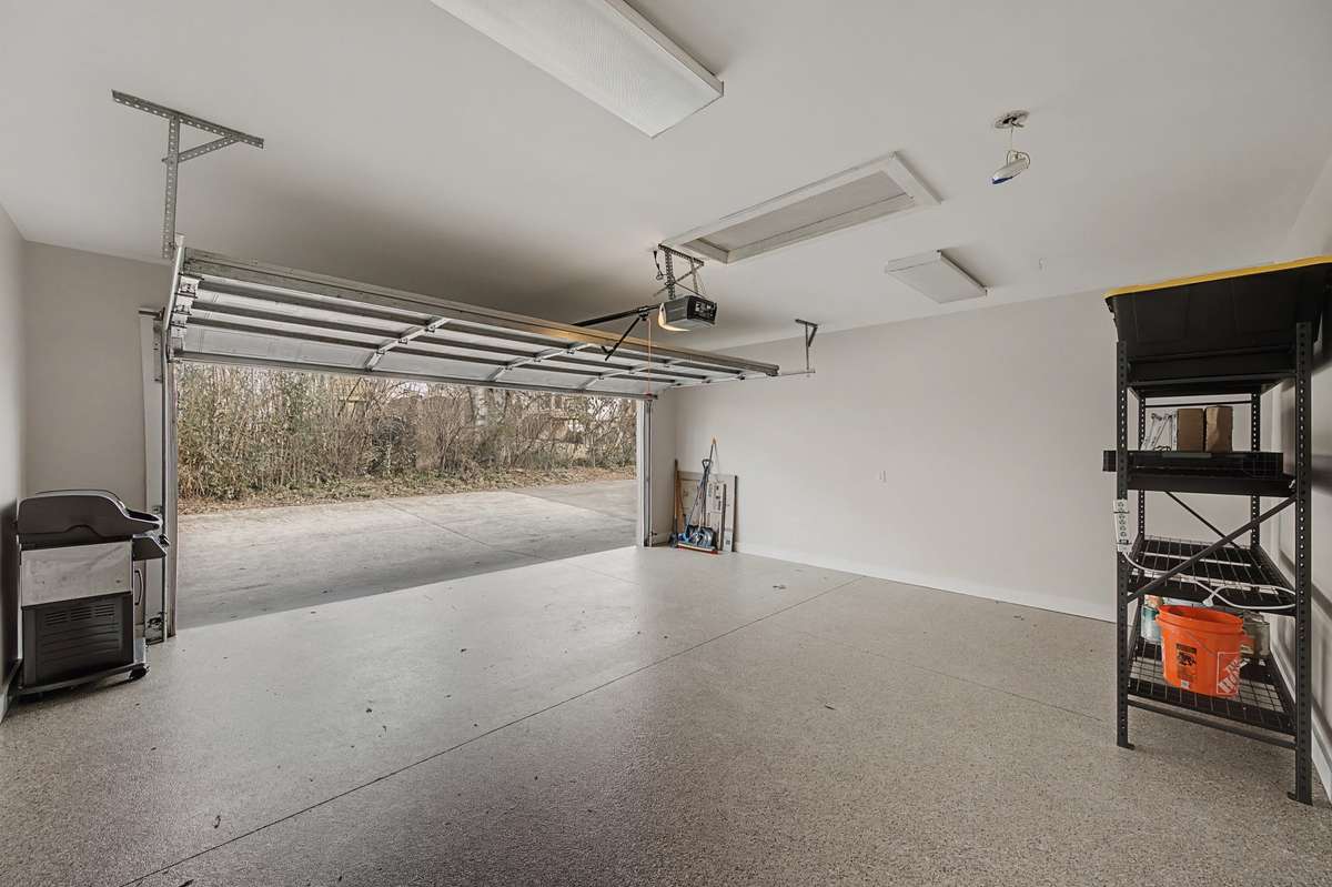 Garage Interior: Spacious two-car garage with finished floors and additional storage shelving