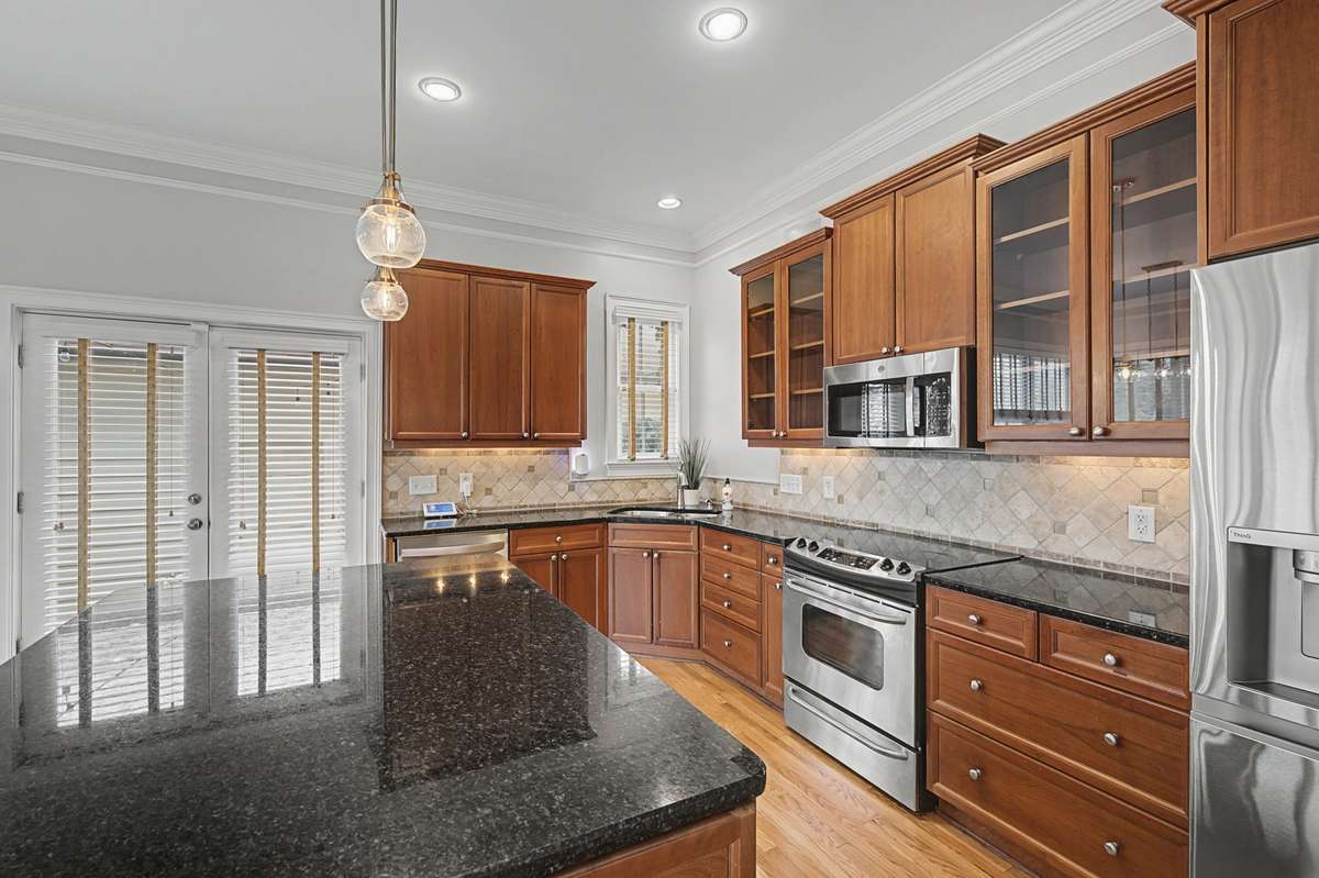 Kitchen:Gourmet kitchen with rich wood cabinetry, granite countertops, and stainless steel appliances
