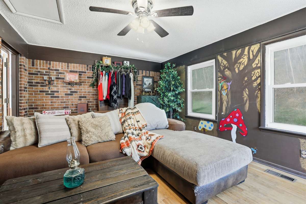 Well lit Den with windows and lighted ceiling fan.