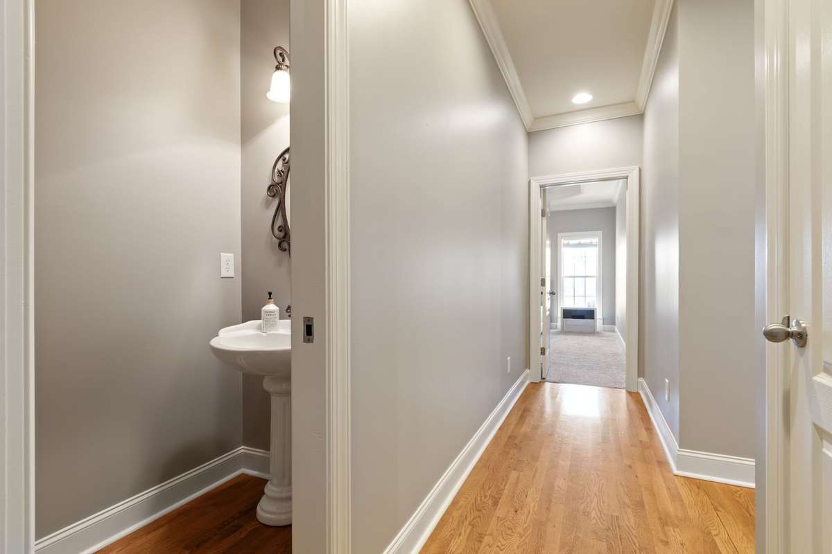 A wide hallway with hardwood floors connects the main living areas to the primary suite.