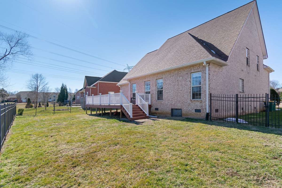 A rear exterior view showcases the brick construction and elevated deck with stair access to the backyard.