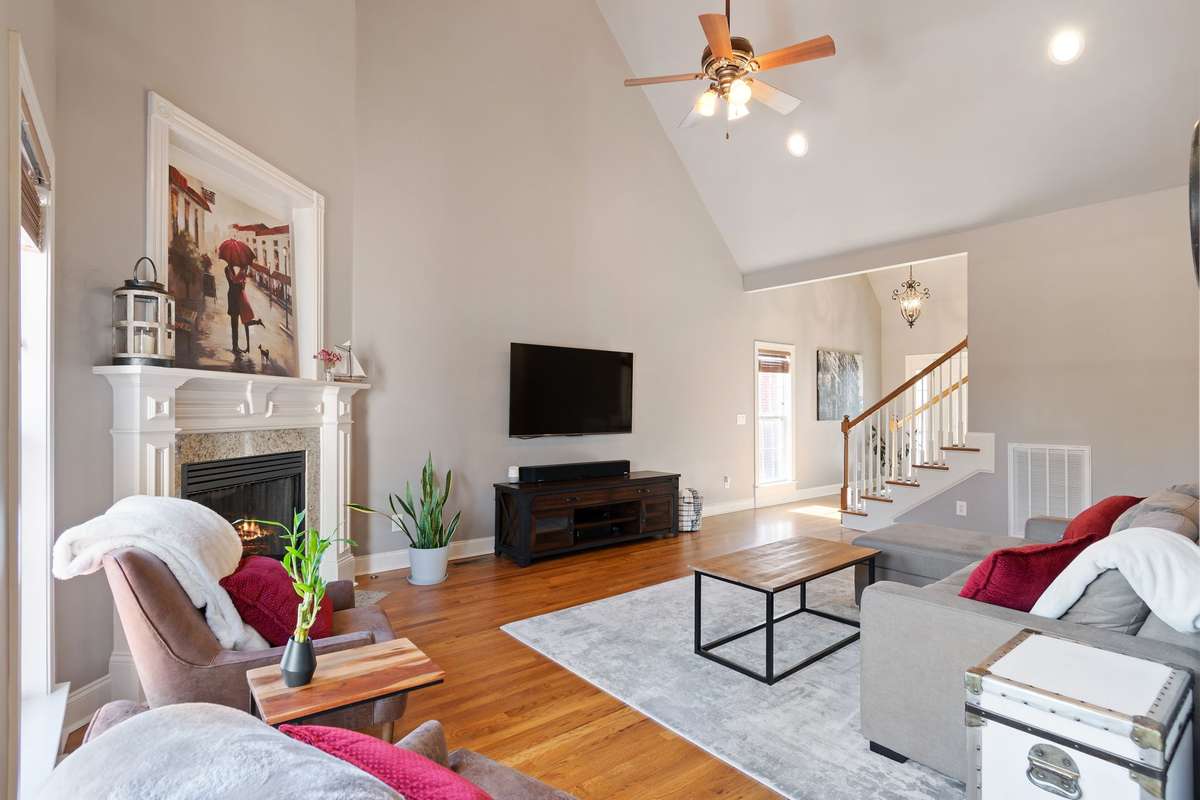 The living room features a vaulted ceiling and ceiling fan, creating a bright, open feel.