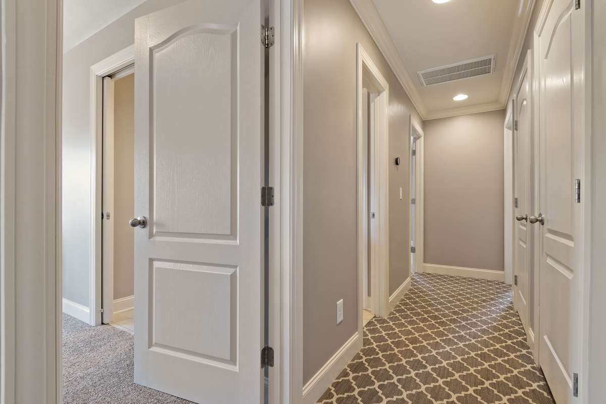 The upper hallway features recessed lighting, crown molding, and carpet installed with the highest quality pad.