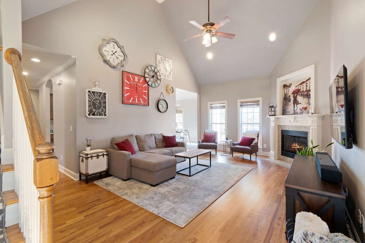 The open-concept living room features vaulted ceilings, hardwood floors, and a cozy gas fireplace.
