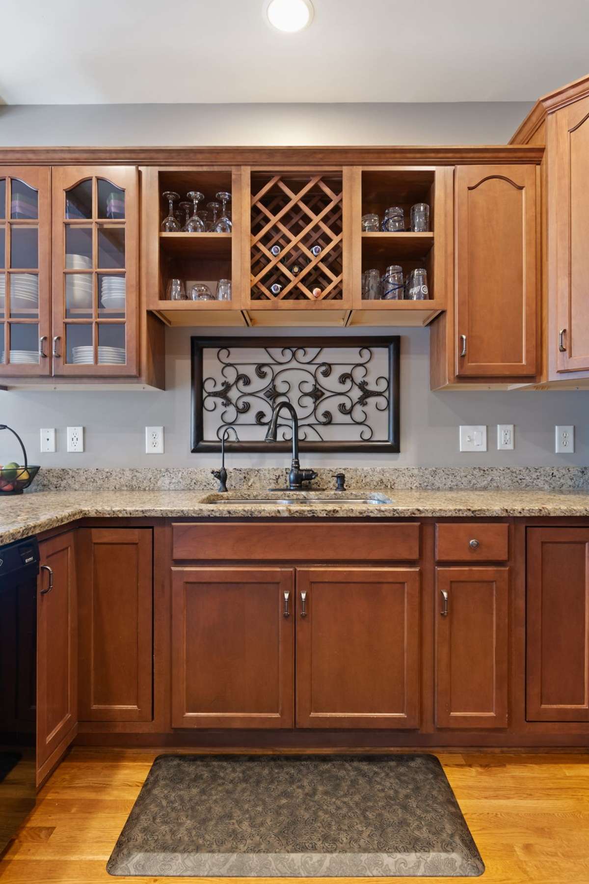The kitchen layout offers ample storage with upper and lower cabinets and a built-in wine rack.