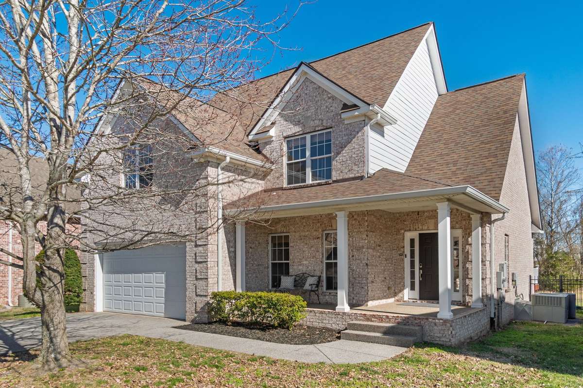 The covered front porch offers a welcoming entry with brick construction and columned supports.