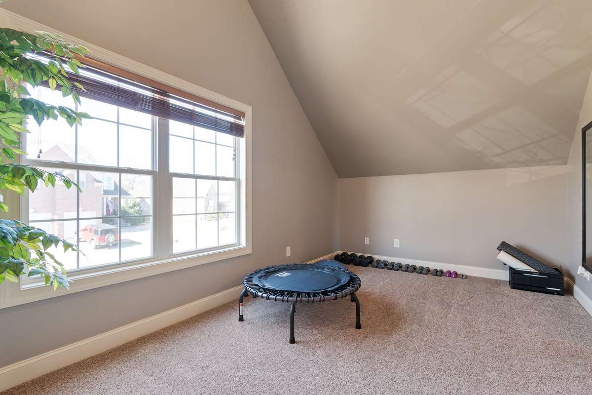 Natural light fills the bonus area through a large window, creating a bright and open feel.