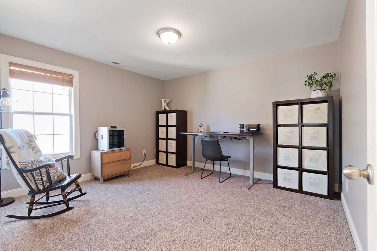 The third bedroom on the second floor offers carpeted flooring, neutral walls, and flexible space for a home office, hobby room, or bedroom.
