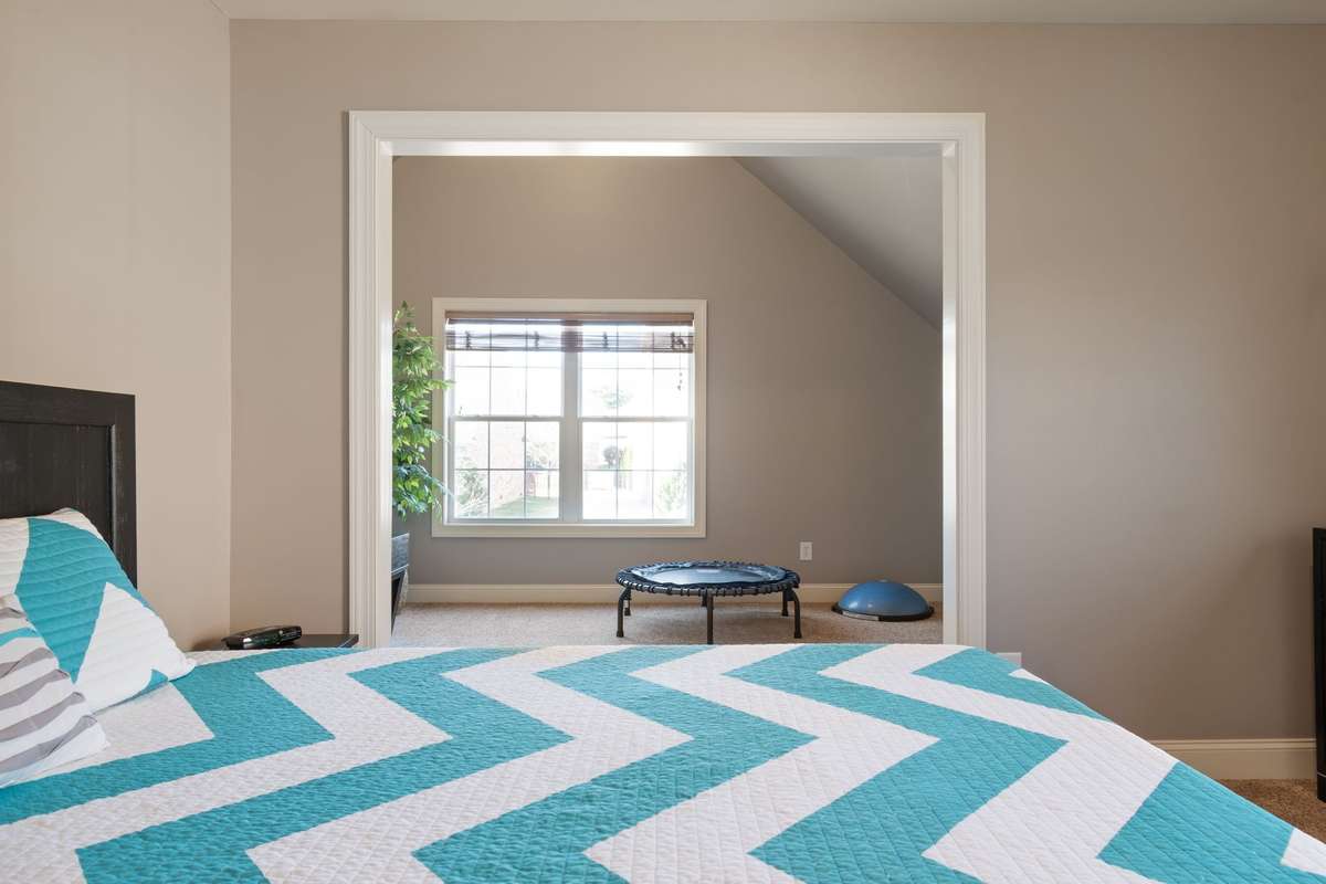 A wide doorway connects the bedroom to an adjoining bonus or sitting area.
