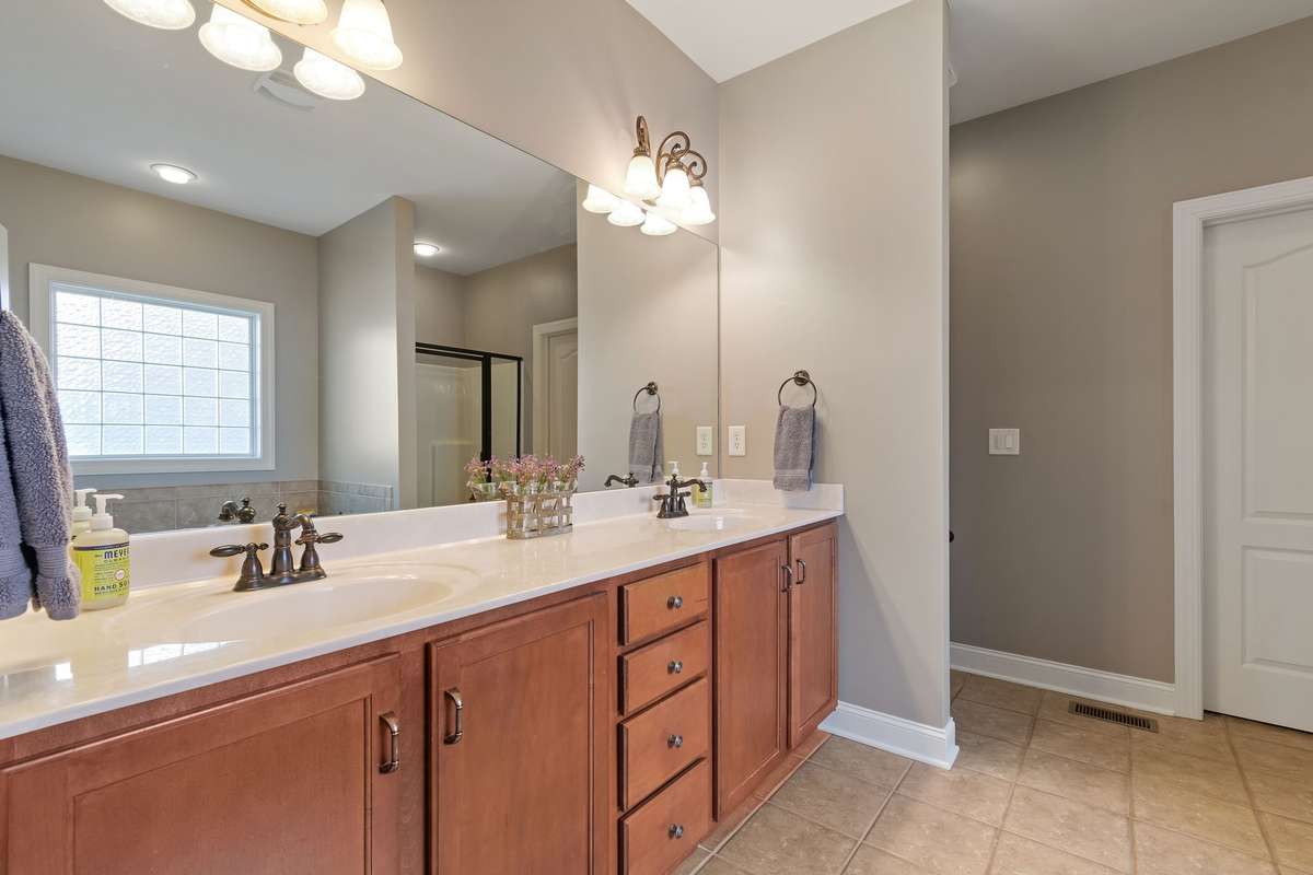 The primary bathroom includes a long double vanity with ample cabinet storage.
