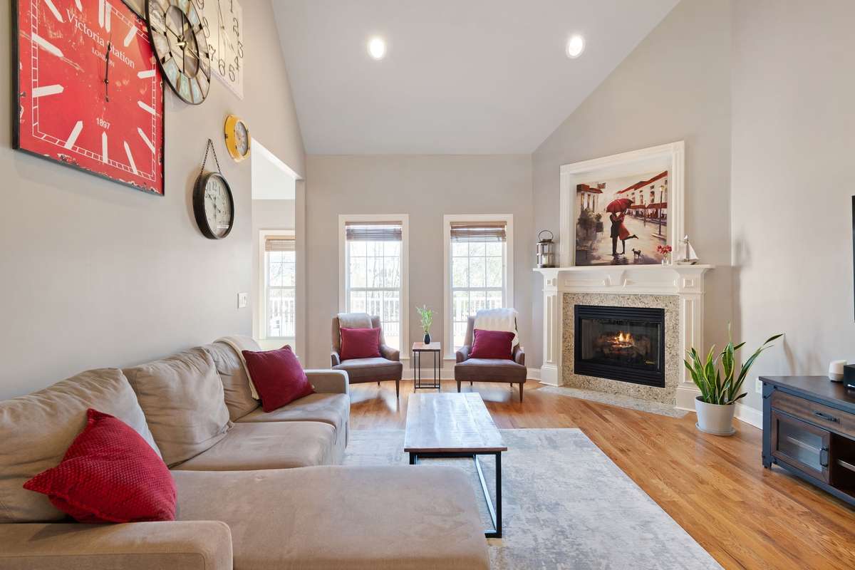 Natural light fills the living room through tall windows, creating a bright and inviting atmosphere.