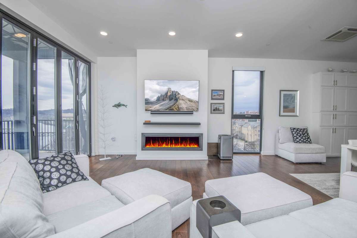 spacious living area with gas fireplace and glass retractable doors.