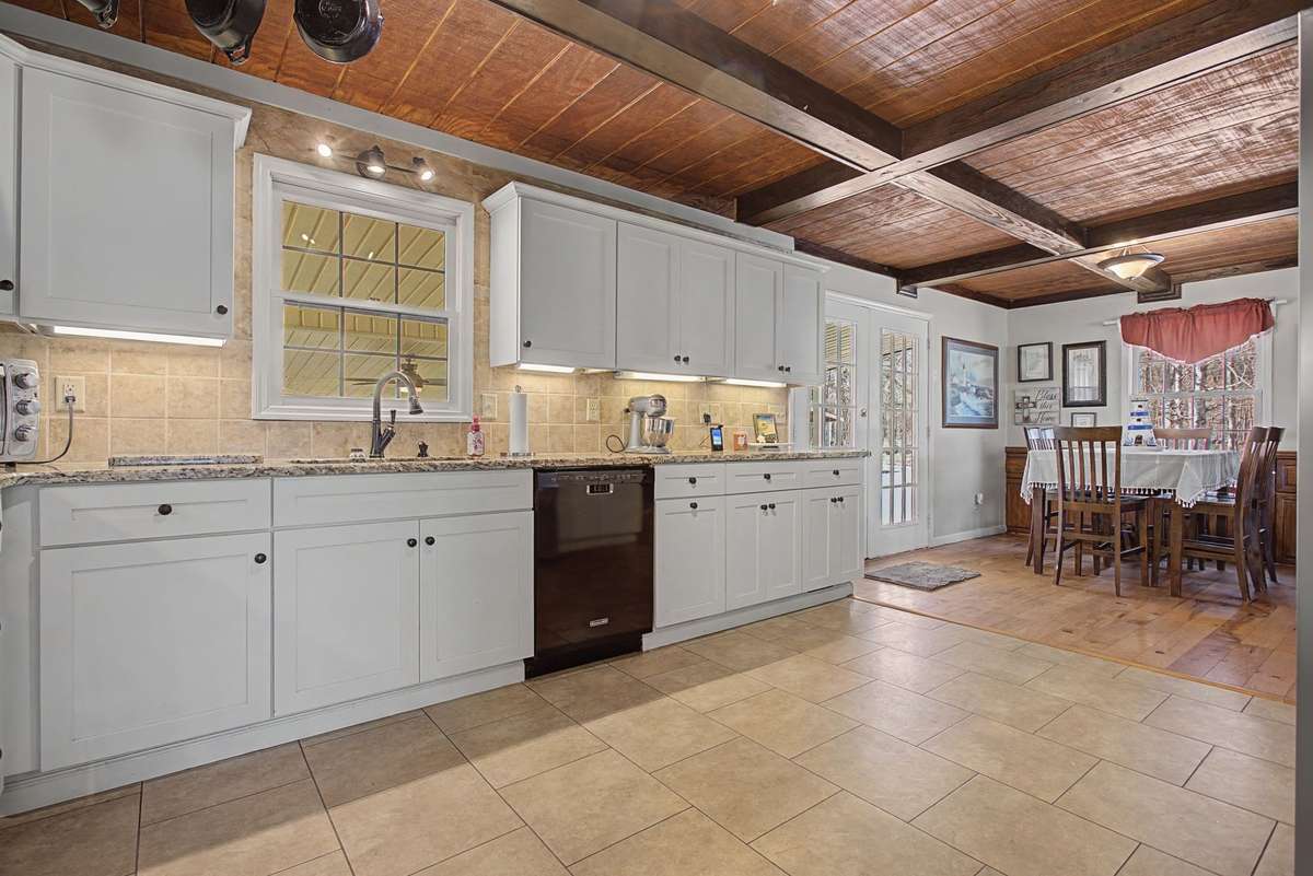 Beautiful wood coffered ceiling, white cabinetry, granite counters and eat in area in kitchen