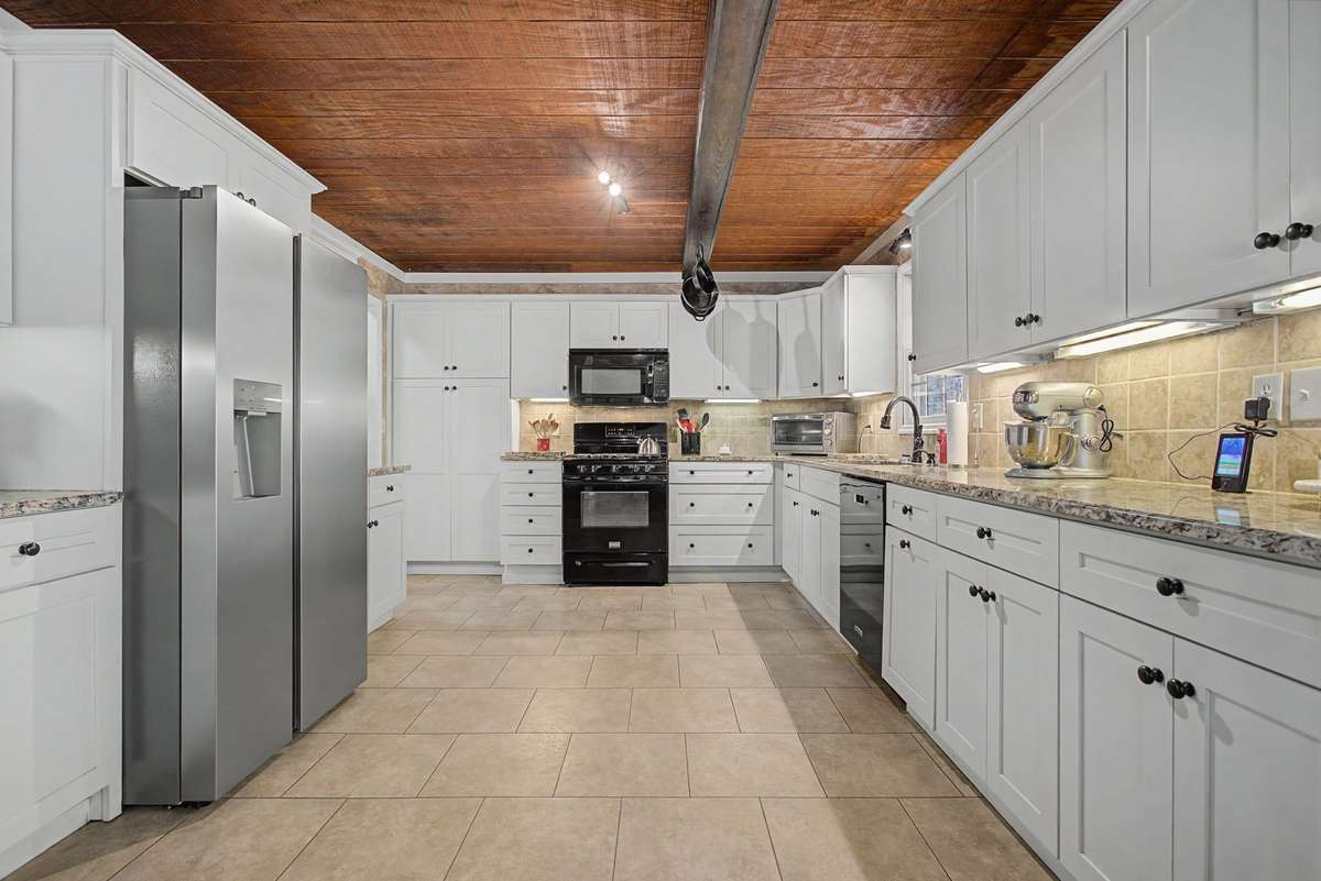 Cheerful white cabinets in Kitchen with granite counters and under cabinet lighting