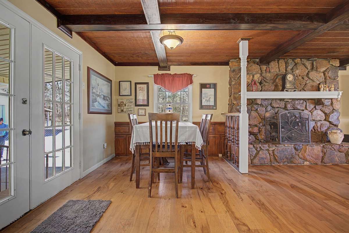 Eat in area, hardwood flooring and view of stone fireplace in adjoining family room