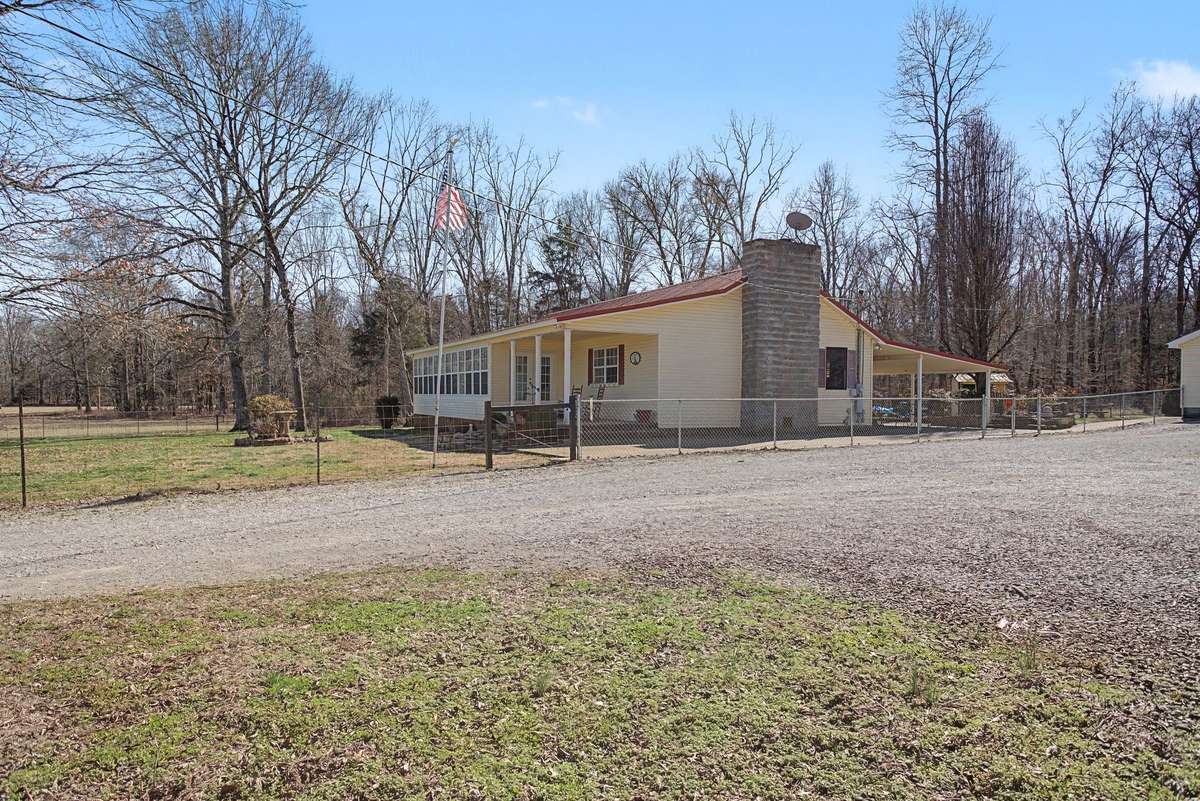 Side view of house showing front porch and driveway area