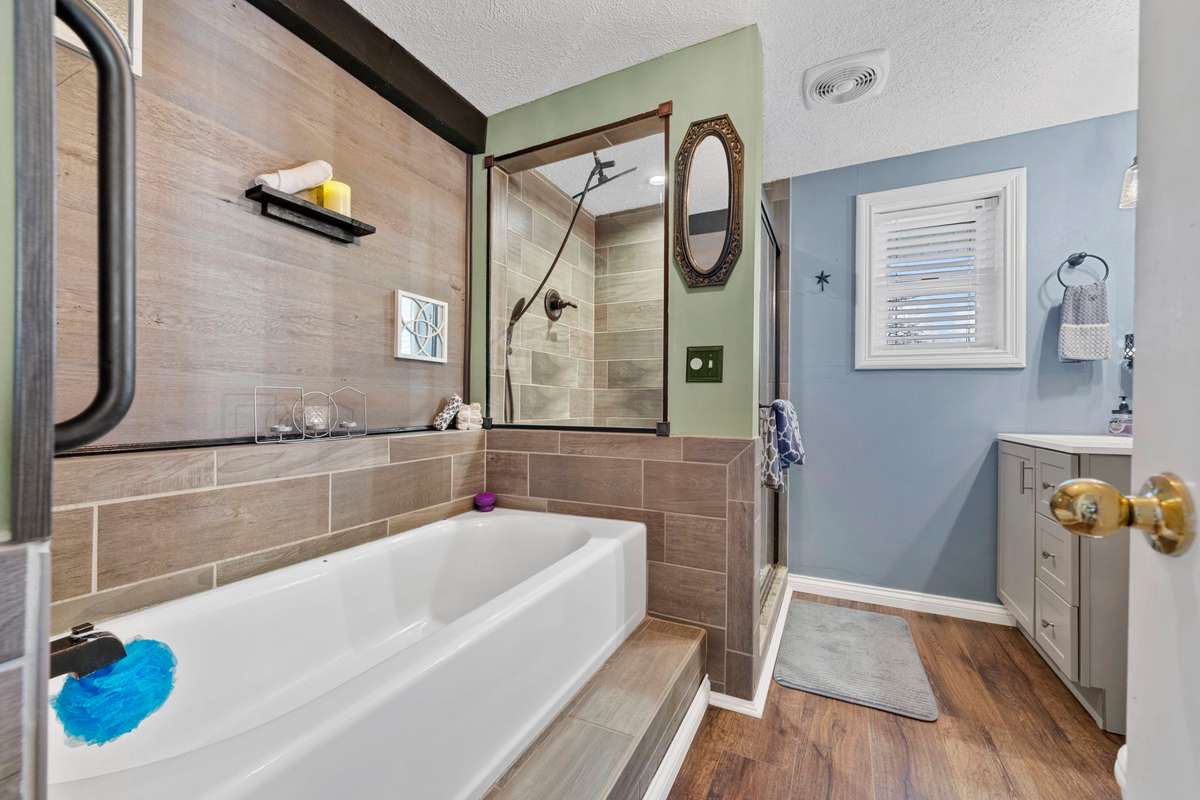 Main floor bath with separate tub & tiled walk-in shower and new waterproof plank flooring.