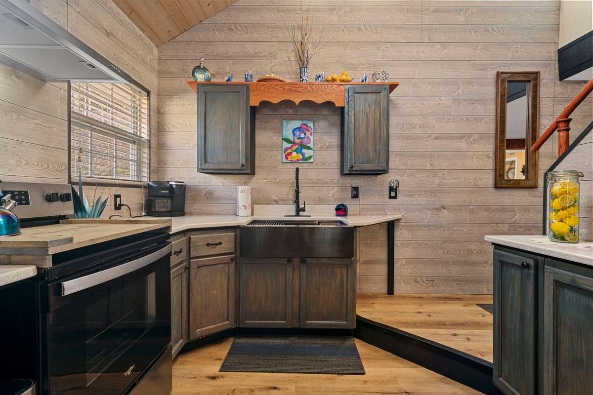 Renovated kitchen with new appliances, farmhouse sink, natural light and high ceilings.