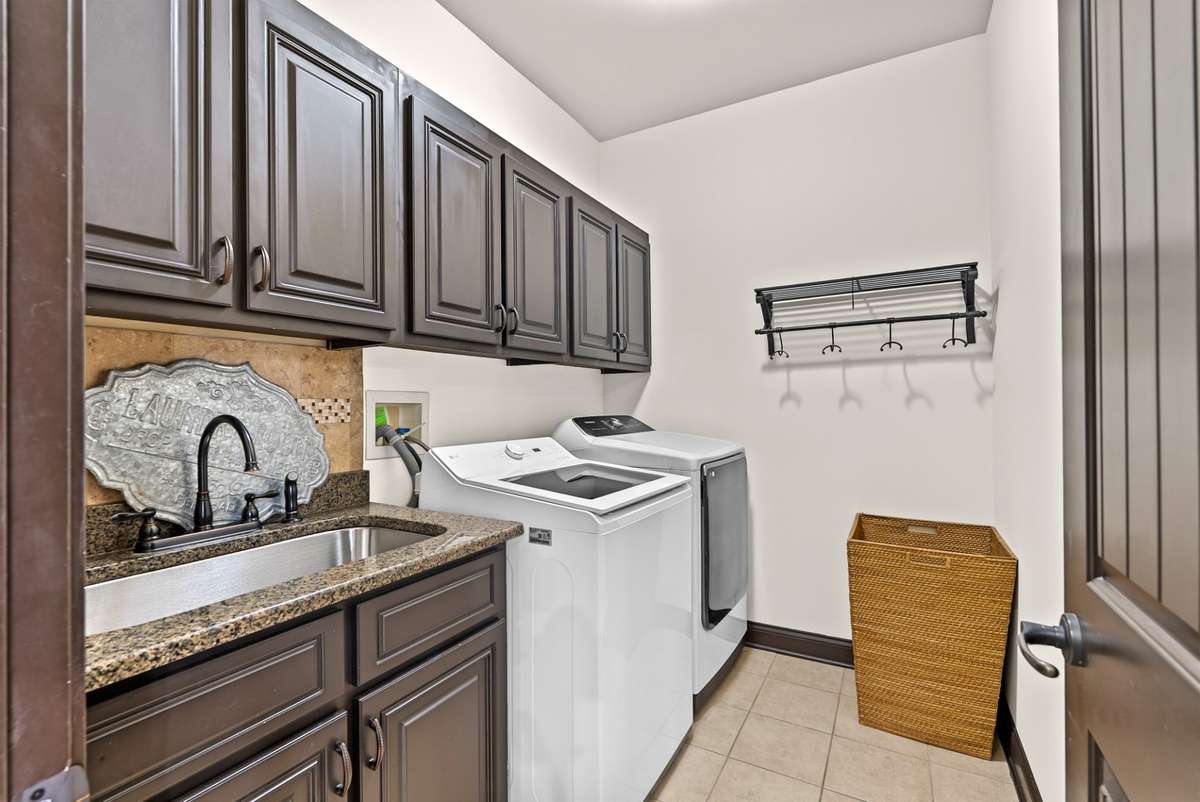 Huge laundry room w/ sink and storage.