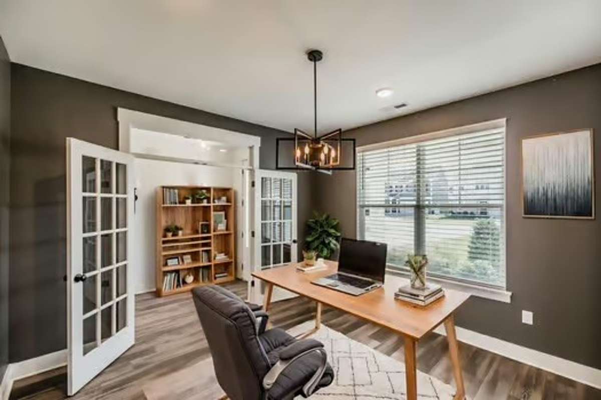 Home office or formal dining room overlooking the covered front porch- virtually staged.