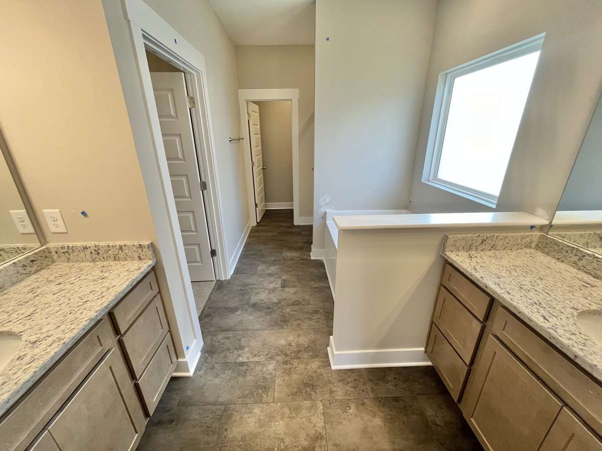 Stock. Does not come with granite in bathrooms but can be an option. Nice large bathroom with separate vanities, garden tub, large privacy window, tile shower and private toilet area