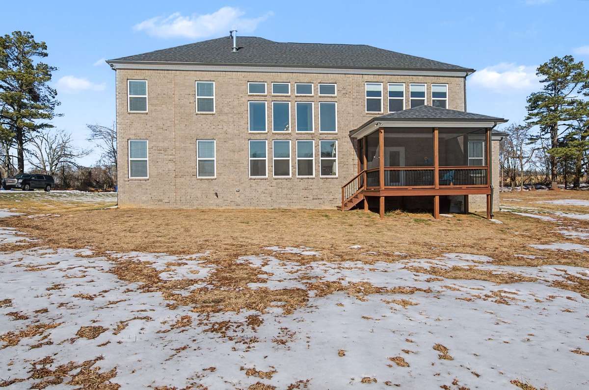 Rear view of the home is all brick and features a great screened in porch for your enjoyment