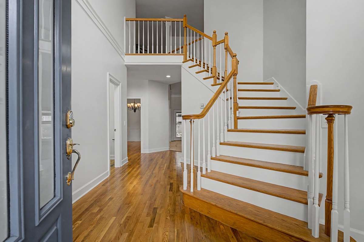 The grand entry has soaring ceilings and hardwood floors that have just been refinished. And the home has been freshly painted. Half bath for guests is down the hall on the left.