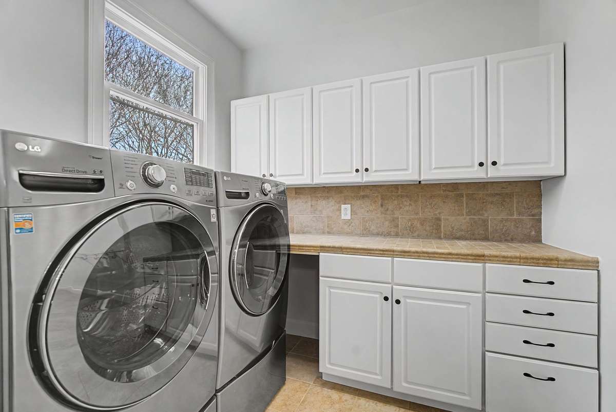 Connected to the primary bathroom is this amazing laundry room and huge walk-in closet.