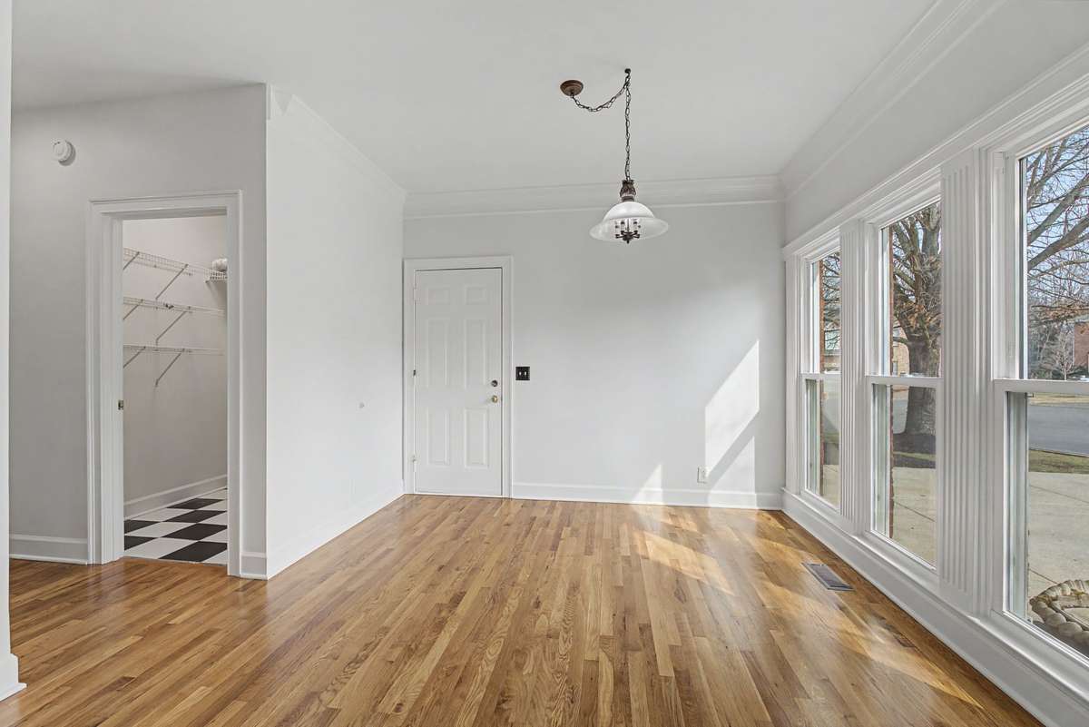 View from the kitchen reveals a spacious casual dining area with beautiful crown molding and tons of natural light from the newer windows.