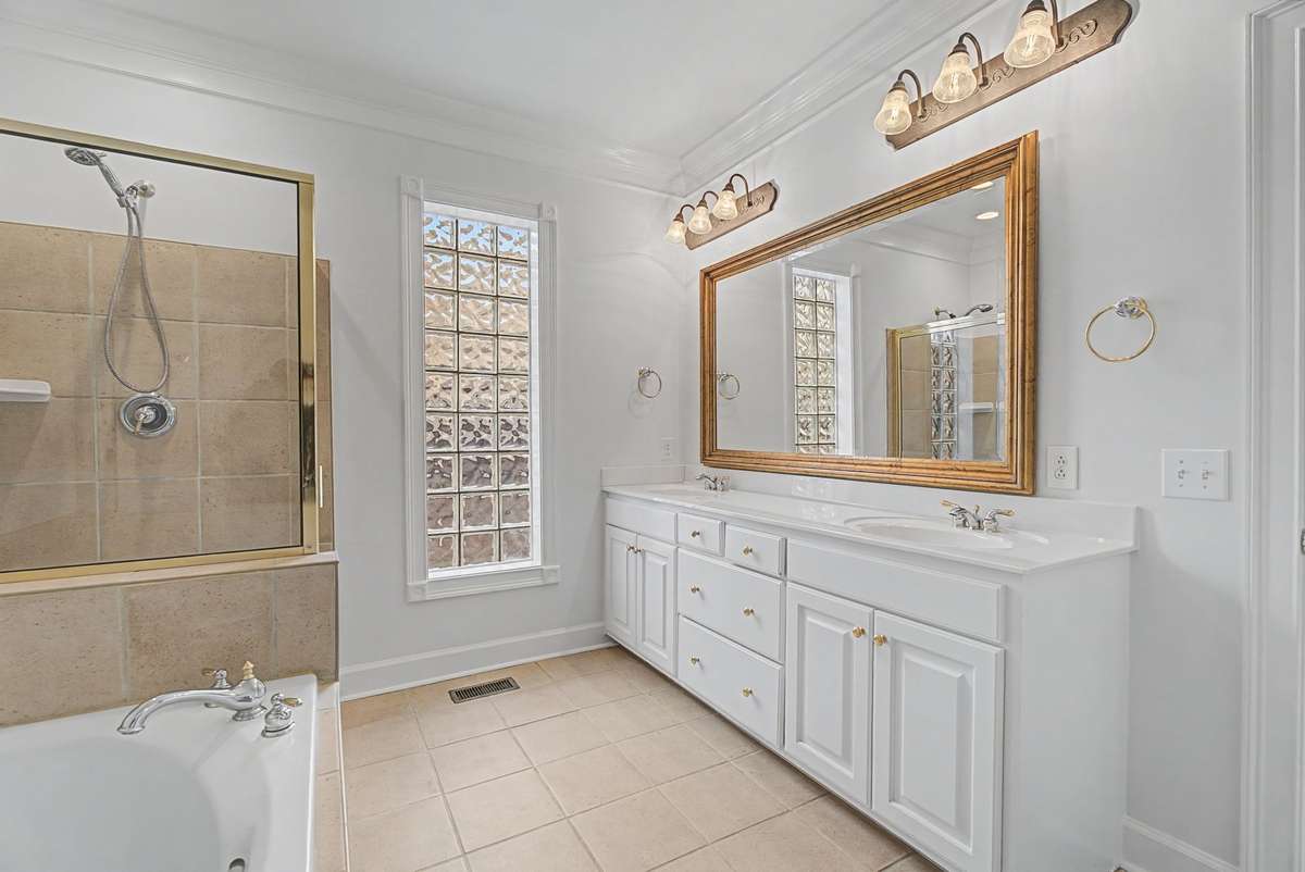 Separate jacuzzi tub and tile shower, with double vanities.