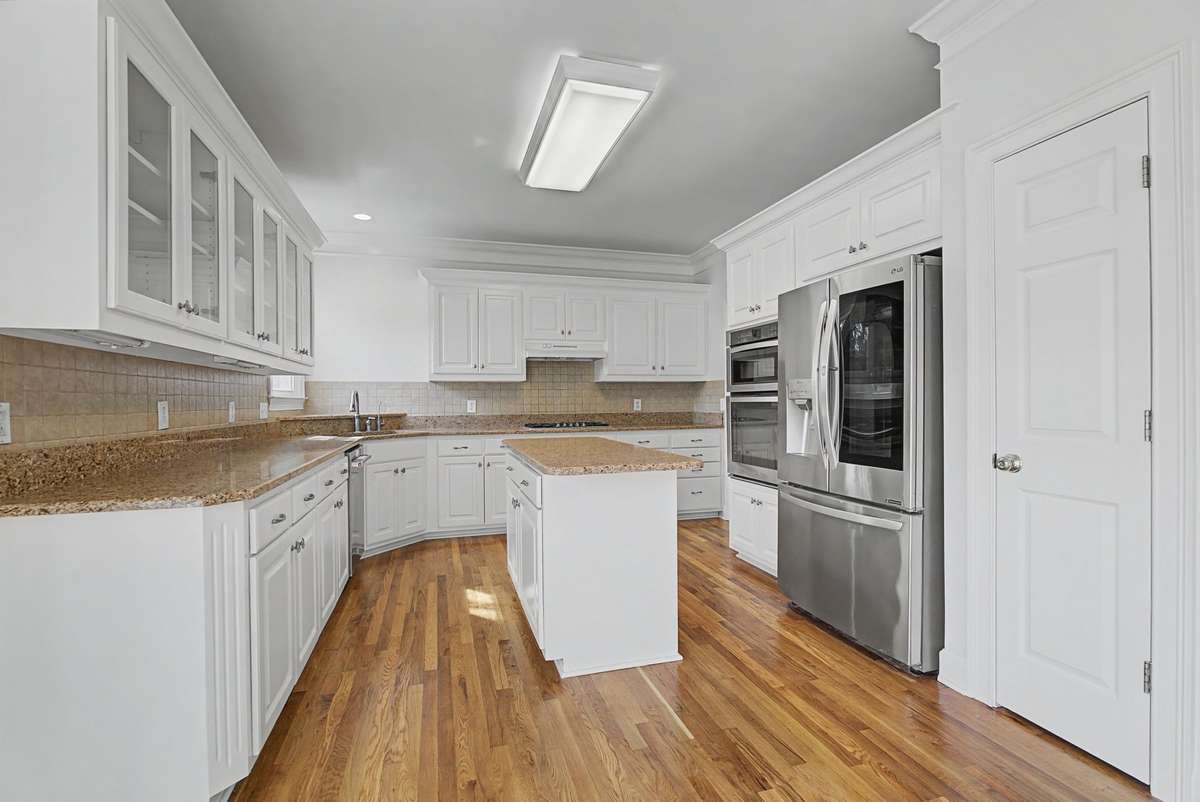 Beautiful kitchen is located on the other side of the dining room.  It has granite counter tops, tile backsplash, and gas stove.  Appliances are only a few years old.